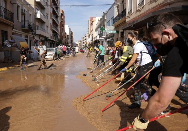 Voluntarios se organizan para retirar barro.