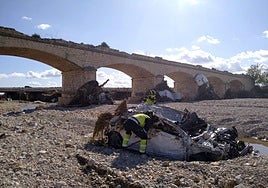 Un bombero de la Diputación de Valladolid rastrea un vehículo en el cauce del río en Chiva, el fin de semana.