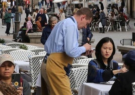 Un camarero toma la comanda a unas turistas en un restaurante de Segovia.