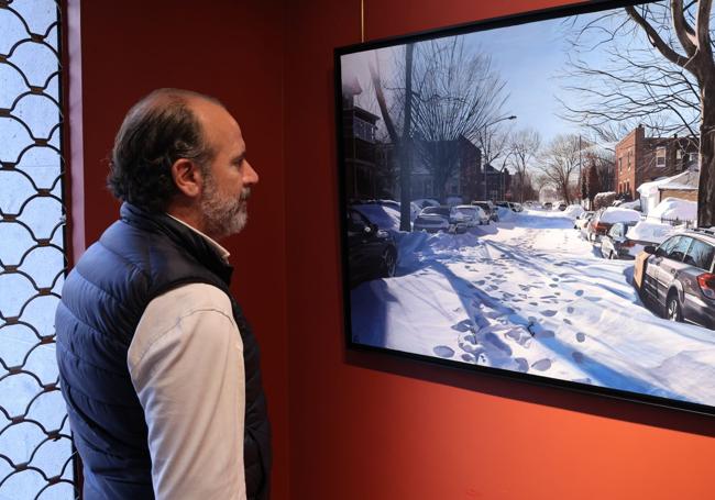 Un visitante observa un cuadro de una calle nevada de Nueva York,