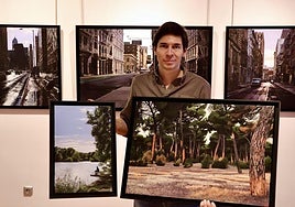 Luis Pérez con dos lienzos del río Pisuerga en San Miguel del Pino y del pinar de Simancas y, tras él, cuadros con paisajes urbanos de Chicago y Nueva York.