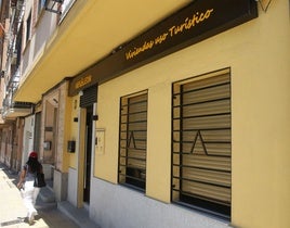 Una mujer pasea junto al acceso a un apartamento turístico.