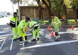 Unos operarios trabajan en reforzar la pintura en una calle de la villa segoviana de Cuéllar.