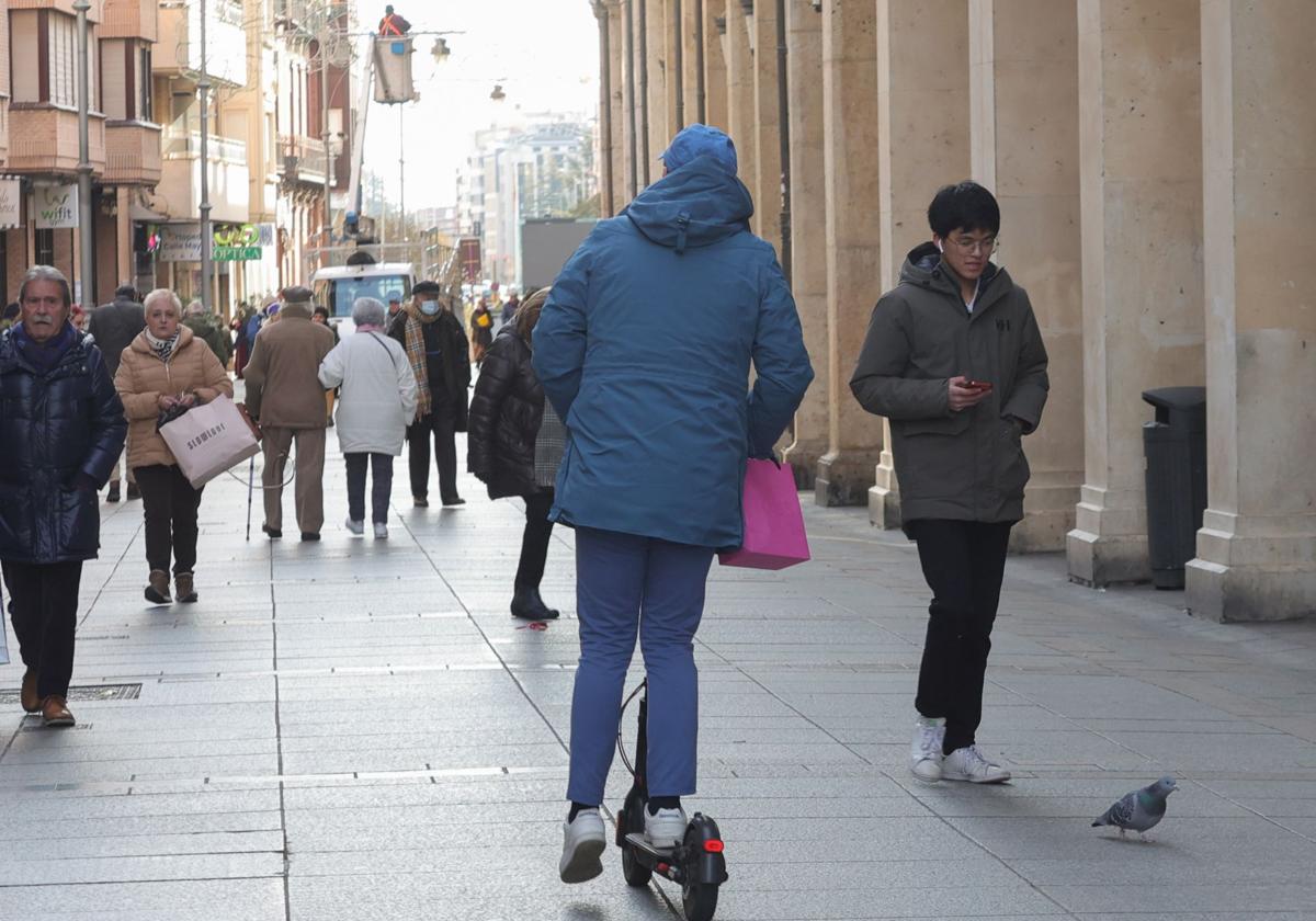 Un hombre circula en patinete por la Calle Mayor.