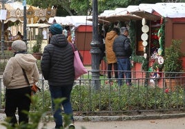 Varias personas caminan por el mercado navideño ubicado en el Paseo del Salón.