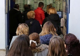 Multitud de personas esperan su turno para adquirir décimos de lotería.