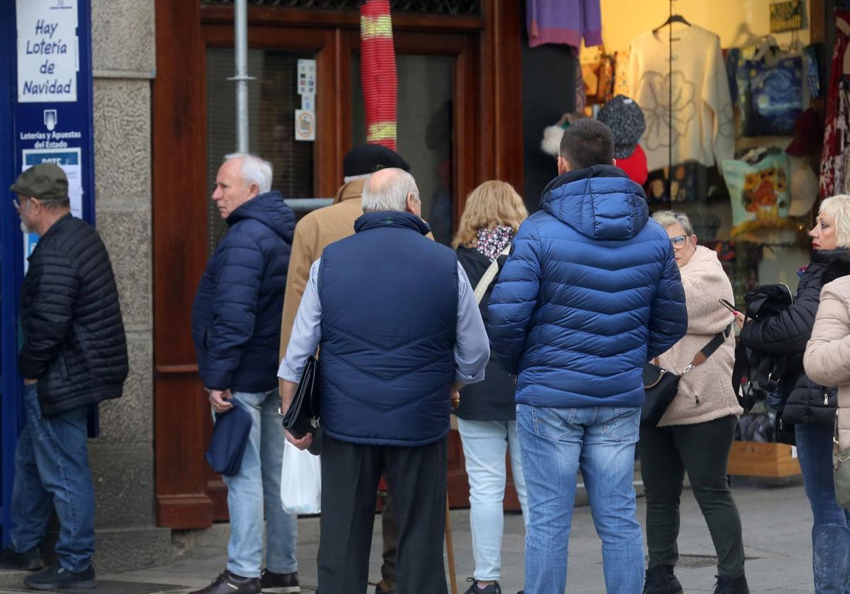 Varias personas hacen cola a las puertas de una administración de lotería en la provincia.