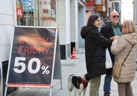 Tres personas conversan junto a un cartel de una firma nacional con tienda en Palencia.