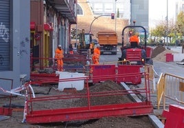 Los operarios trabajan en el adoquinado de las aceras del lado de las viviendas de la calle Transición.