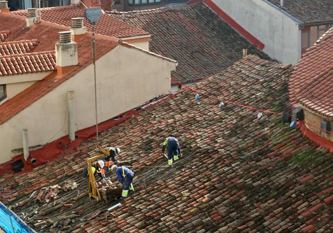 Los operarios retiran las tejas de la cubierta del teatro.