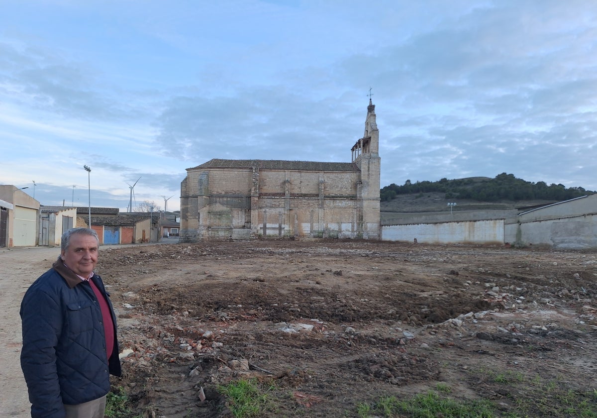 El alcalde, en la parcela desescombrada, con la fachada de la iglesia que ha quedado al descubierto.