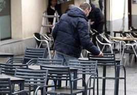 Un trabajador prepara una terraza en una céntrica calle de Segovia.