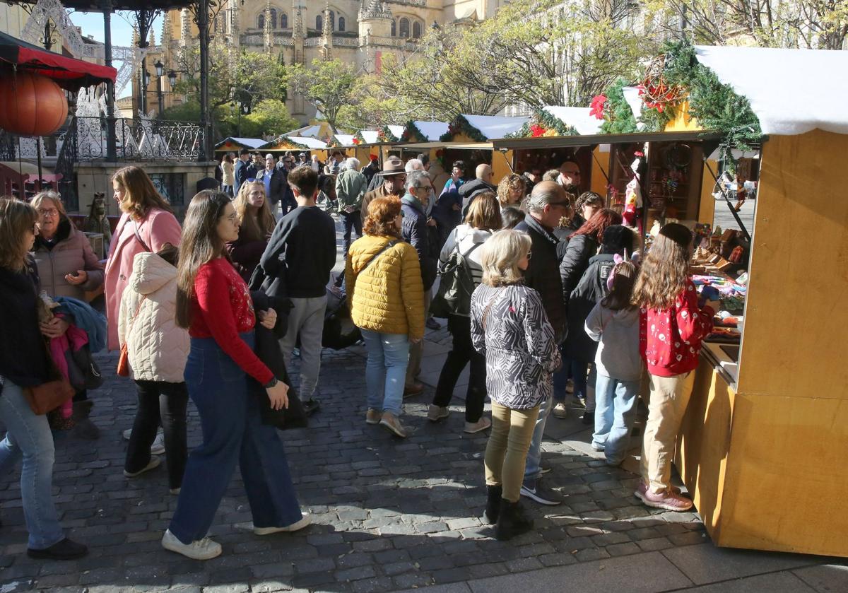 Decenas de personas visitan las casetas del mercadillo navideño.