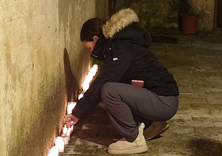 Una mujer enciende una vela