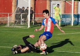 Jesús Torres trata de esquivar la entrada de un rival.