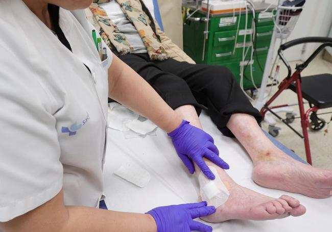 Una profesional de Palencia cura las heridas de una paciente.