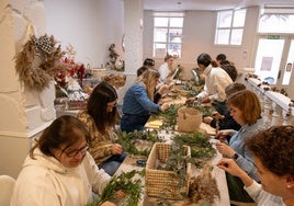Participantes en el taller se afanan en el montaje creativo sus coronas navideñas