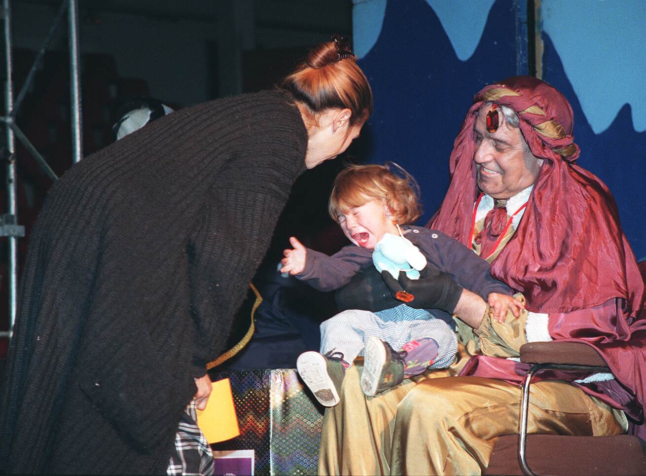 El Rey Baltasar sostiene en brazos a un niño durante la III Campaña de Recogida de Juguetes organizada por el grupo de radioaficionados del Radio-Club Cultural Gaviota y el Ayuntamiento de Valladolid. 2 de enero de 1999.