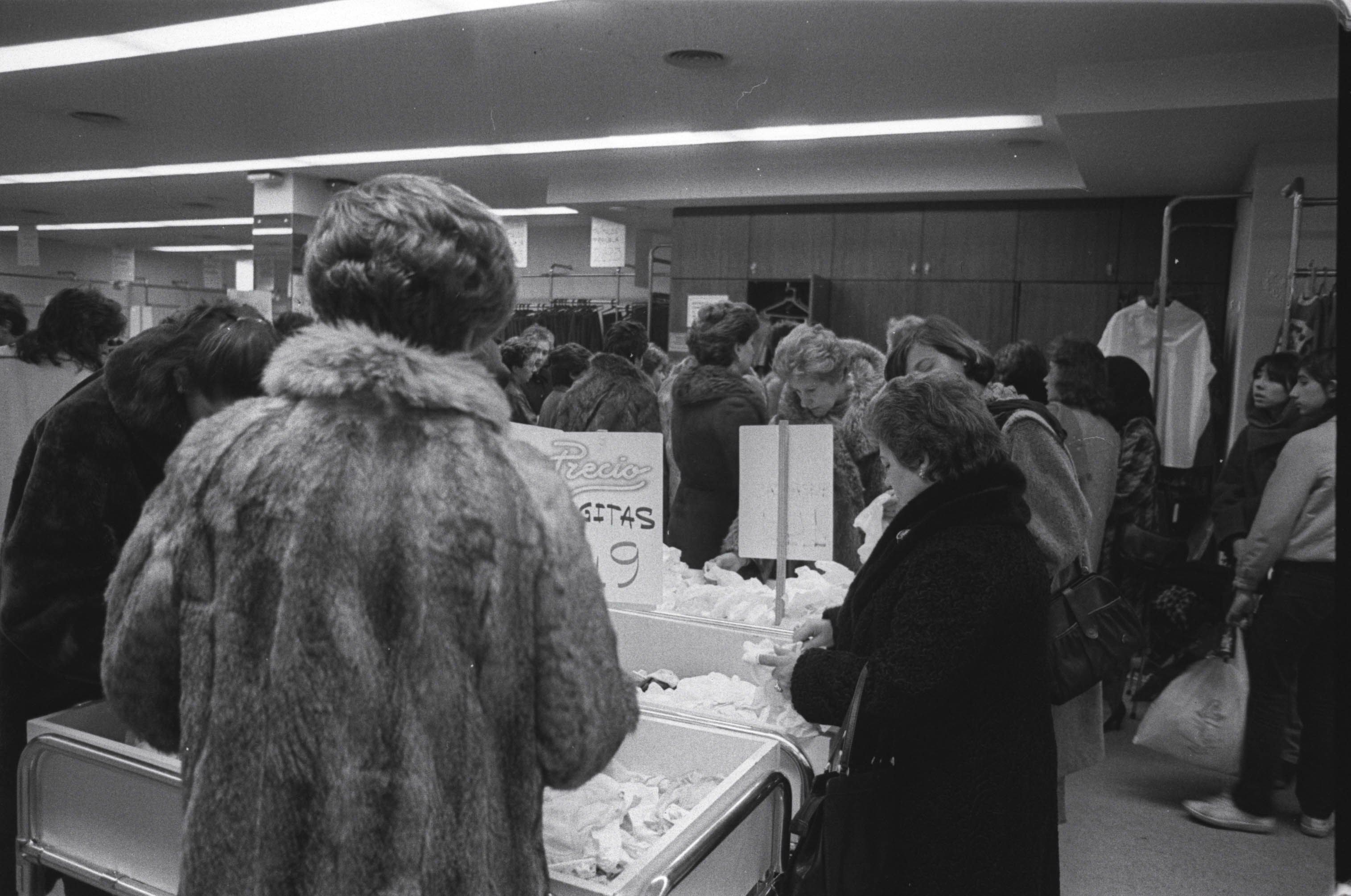 Varias personas realizan compras en las rebajas de Navidad en un comercio de Valladolid. 10 de enero de 1986.