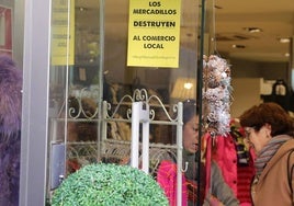 Cartel reivindicativo colgado en el escaparate de una tienda de ropa.