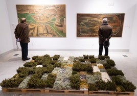 Instalación de Carmen Madreñarroja con elementos de la naturaleza frente a dos óleos judiciales del Archivo de la Real Chancillería.