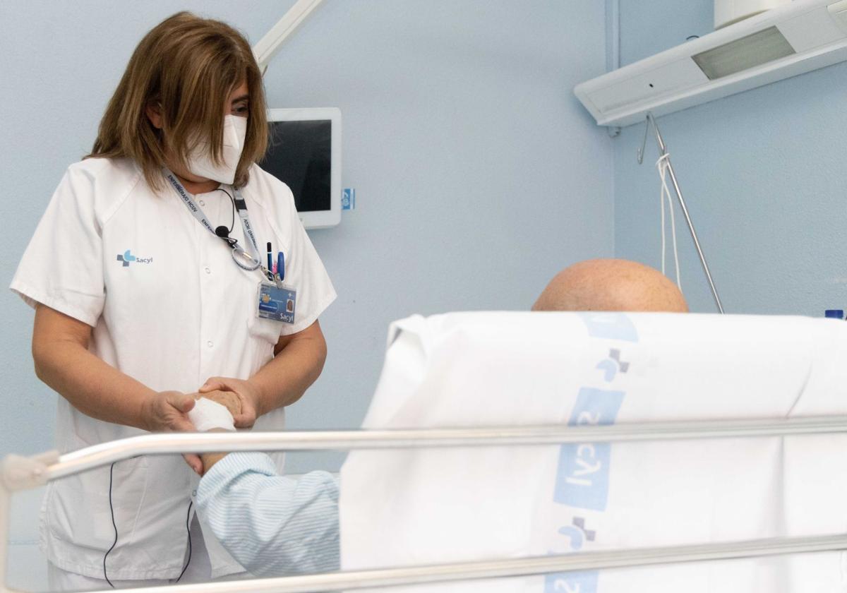 Una enfermera atiende a un paciente oncológico en el Hospital Clínico de Valladolid.