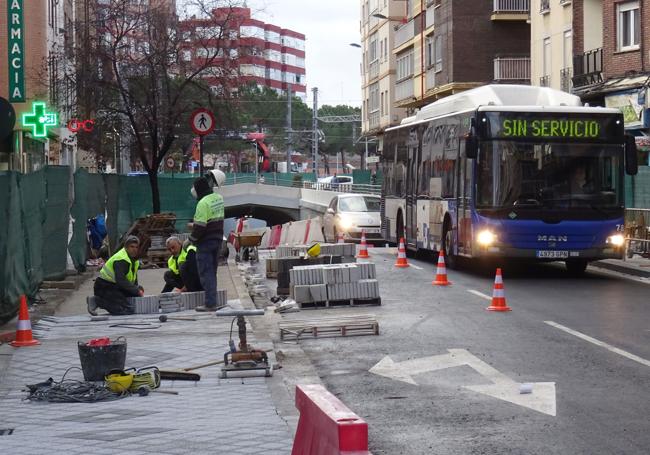 Los operarios rematan el adoquinado de la acera del lado de los números impares en la calle Labradores, a la salida del túnel.