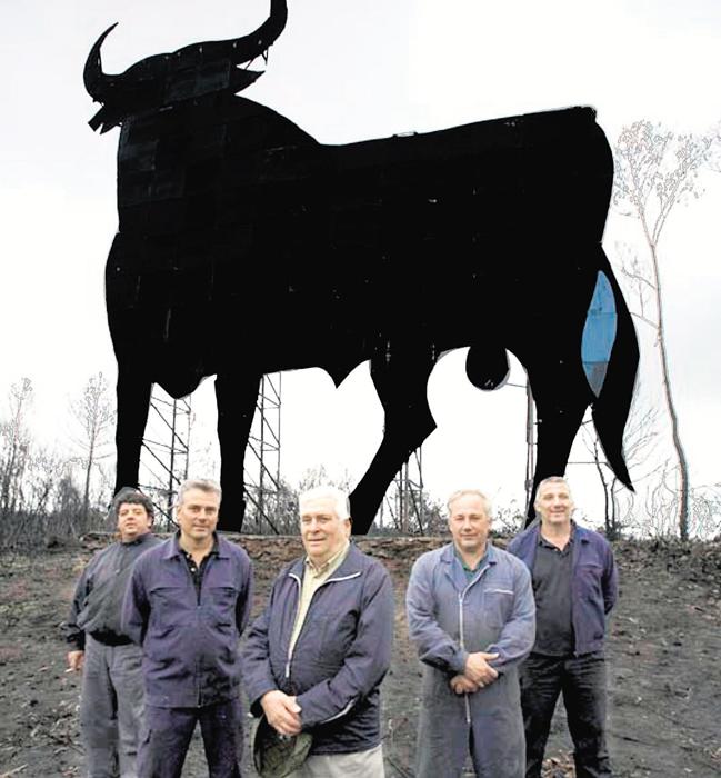 Félix Tejada Prieto, flanqueado por sus hijos y un operario ante uno de sus famosos toros, en 2013.