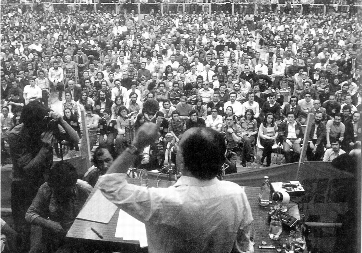 Imagen principal - Arriba, primer mitin del PCE en la legalidad, celebrado en el polideportivo Huerta del Rey el 23 de abril de 1977. Abajo, Memorial del Cementerio del Carmen, donde está enterrado un tío segundo de Santiago Carrillo, y anuncio de la intervención de su padre en Valladolid en octubre de 1927.