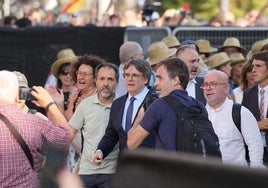 Decenas de 'extras', con sombreros aguardan el momento de colaborar en la huida de Puigdemont de Barcelona.