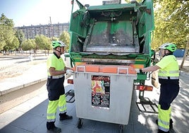 Operarios del Servicio de Limpieza vacían un contenedor de basura.