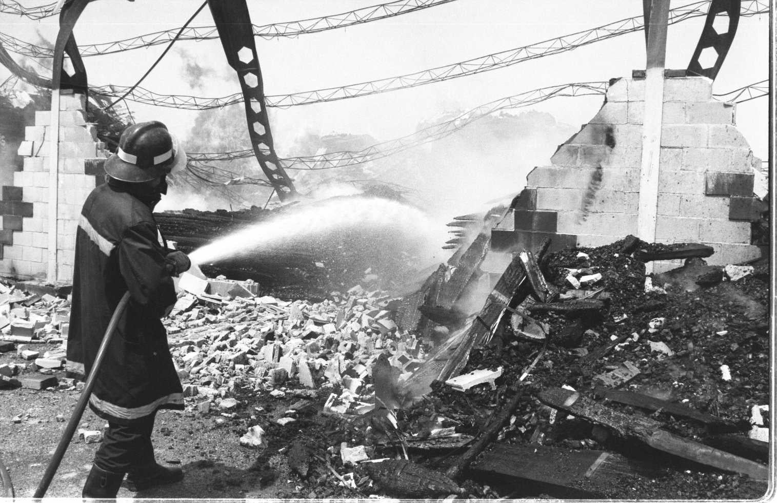 Un bombero trata de apagar un incendio en un almacén de maderas. Enero de 1997.