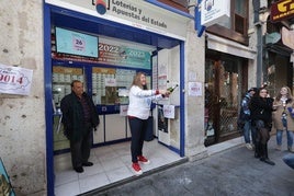 La lotera de la calle Lencería de Valladolid descorcha botellas de champán para celebrar el premio.