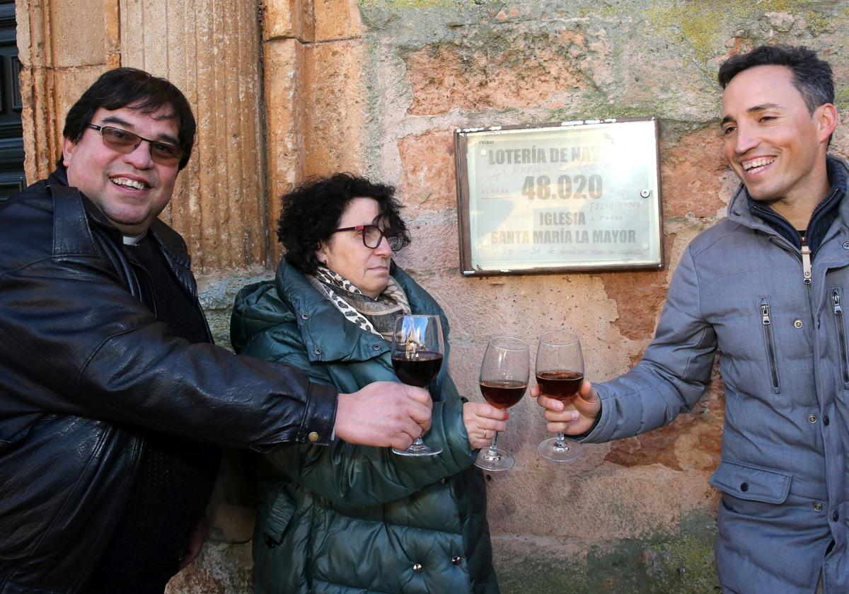 El párroco Emmanuel Becerra, la feligresa Rocío Feliux y el representante de la administración de Lotería que ha emitido el décimo premiado, Iván Nieto.