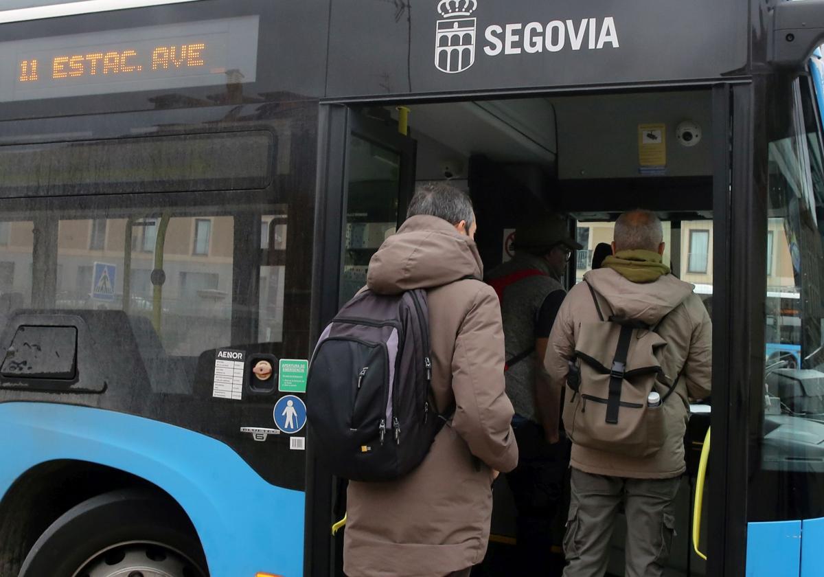 Varias personas suben con equipaje al autobús en dirección a la estación del Ave en Segovia.