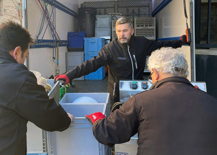 Trabajadores de La Trébede cargan en un camión varias comidas preparadas para su reparto.