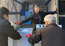 Trabajadores de La Trébede cargan en un camión varias comidas preparadas para su reparto.