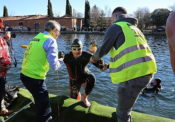 Miembros de la organización ayudan a uno de los participantes a salir del Canal.