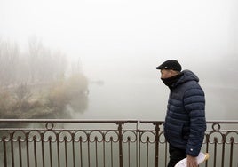 Un hombre camina entre la niebla por un puente en Valladolid, hace unos días.