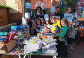 El chef palentino Roberto Espeso y niños de Husillos posan junto a los juguetes recaudados para Algemesí.