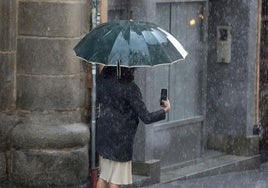 Una mujer graba un momento de la granizada que batió récord de precipitación en mayo.