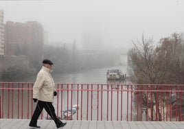 Un hombre pasea por el centro de Valladolid, cubierto de niebla.