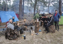 Un grupo de motoviajeros alcarreños (derecha) comparte sobremesa con sus vecinos de acampada en Cantalejo.