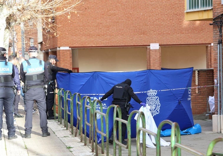 La Policía cubre con una lona el lugar en el que la víctima se ha desplomado.