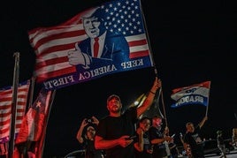 Partidario de Donald Trump con una bandera.