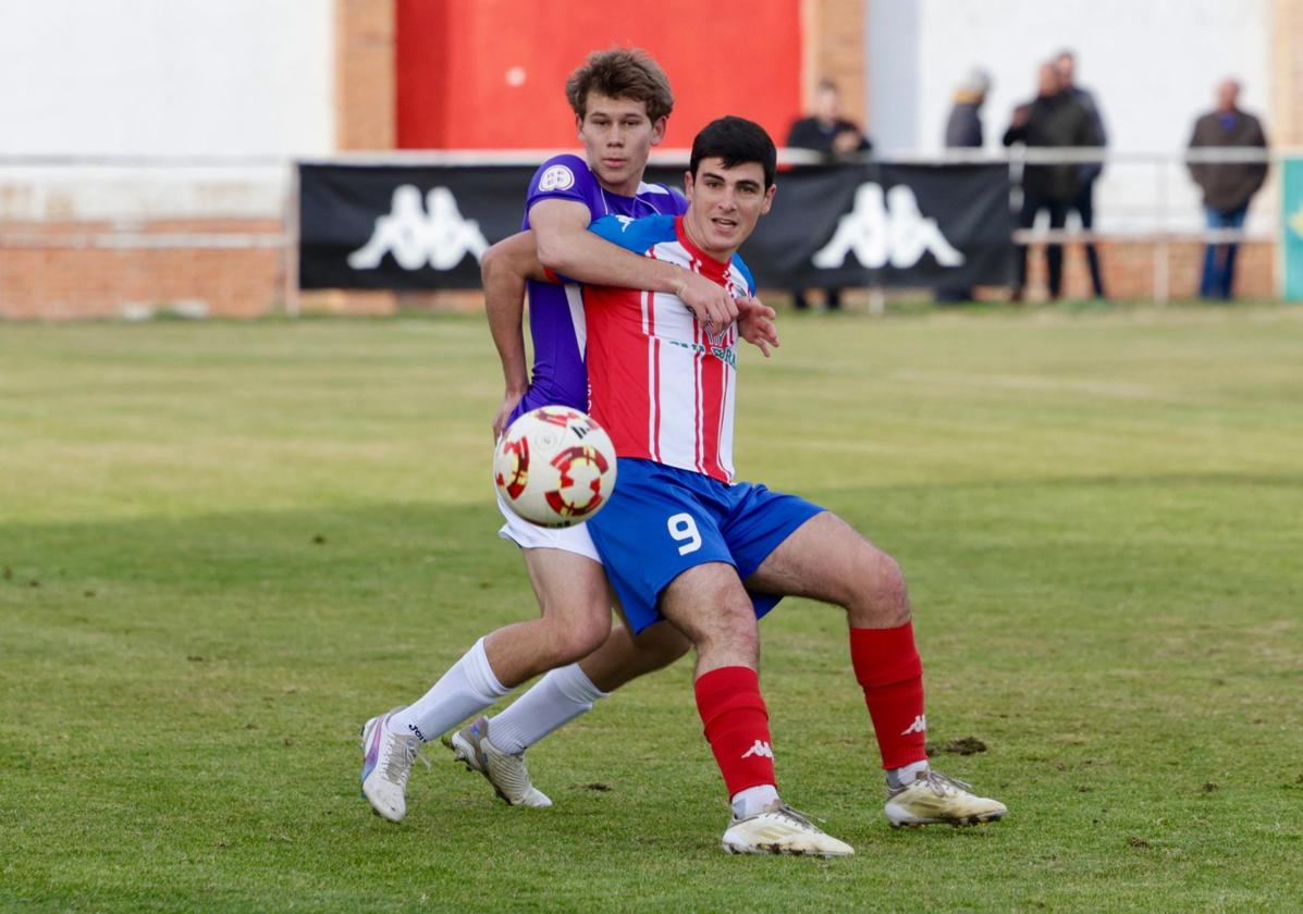 Jesús Torres recibe de espaldas, presionado por un rival.