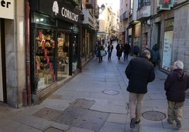 Varias personas caminan junto a los comercios de la Calle Real.