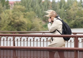 Una mujer se protege del viento en Valladolid, en una imagen de archivo.