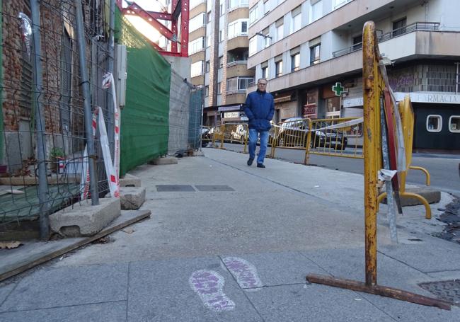 En el suelo, las huellas de la ruta segura al colegio, quec ruzan el paso peatonal cerrado por el riesgo de desprendimientos del edificio abandonado en Caño Argales.