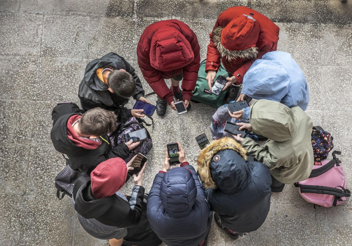 Adolescentes usan sus teléfonos móviles.